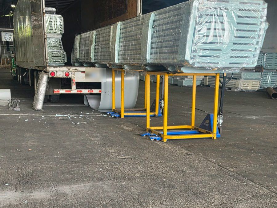 Remolque cargado con carga envuelta junto a soportes en bodega